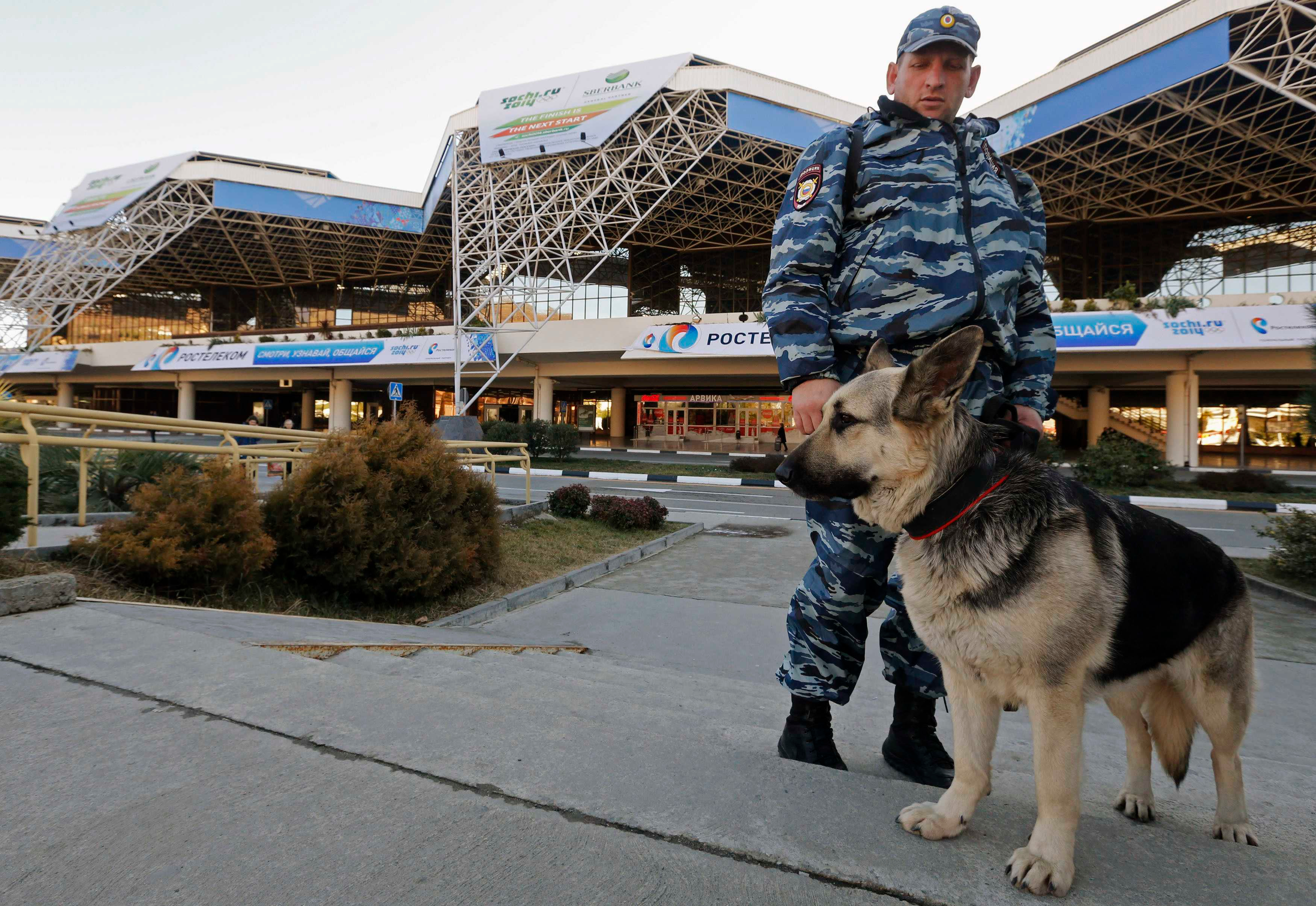 Policeman Vladislav and Lora, a german shepherd sniffer dog, stand guard in front Sochi's airport in Adler, January 15, 2014. Finland's sports and culture minister will boycott the opening of the games over Russia's human rights record. u00e2u20acu201d Reuters pic