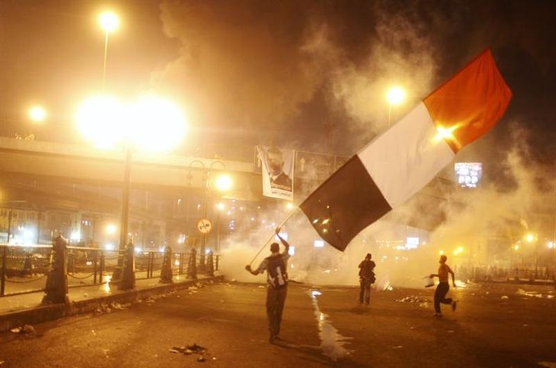 Supporters of Egyptian president Mohamed Mursi waving a national flag run from tear gas during clashes with riot police at the 6th October Bridge in the Ramsis square area in central Cairo July 15, 2013. Malaysian PSD students can choose to continue their studies back home in light of the growing violence in Egypt. — Reuters pic