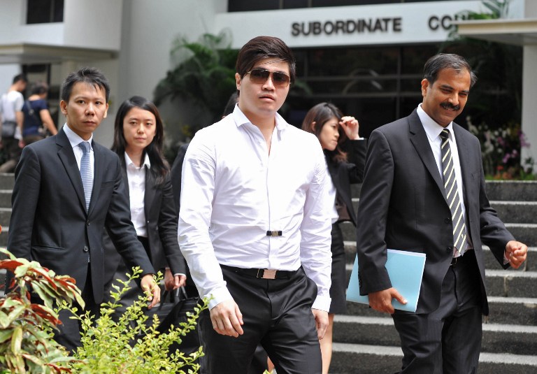 Singaporean businessman Eric Ding Si Yang (entre) leaves a district court with his lawyers during a break on the first day of his corruption trial in Singapore on July 15, 2013. u00e2u20acu201d AFP pic