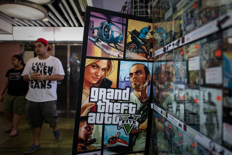 A man walks past a billboard of the 'Grand Theft Auto V' video game in Hong Kong on September 17, 2013. u00e2u20acu201d AFP pic