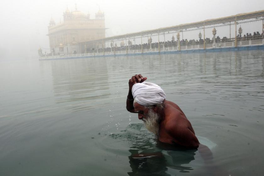 A Sikh devotee takes a dip in fog covered pond on the premises of the Golden temple on a foggy day in the northern Indian city of Amritsar. December 17, 2013.u00e2u20acu2022 Reuters pic