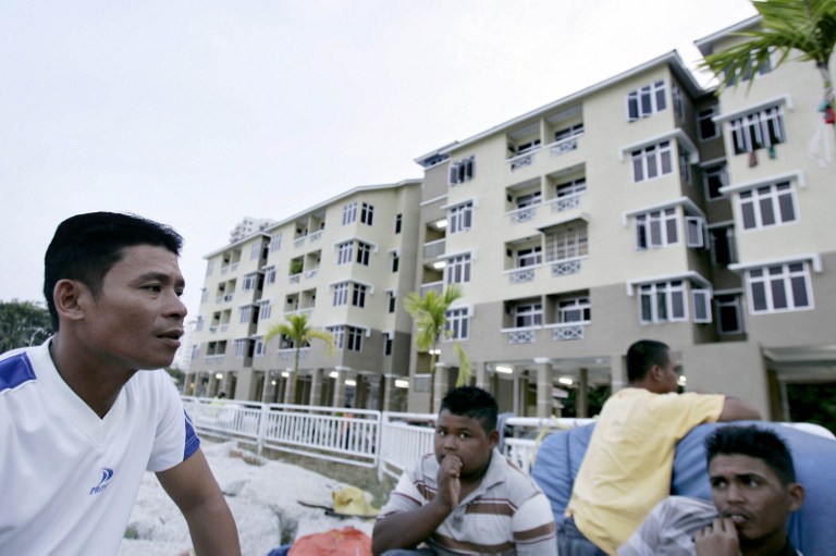 Resident sit together at dusk outside their apartment complex in Tanjung Bungah in northern Penang state on February 23, 2008. The government has said it will refine the MyHome housing programme. u00e2u20acu201d AFP pic