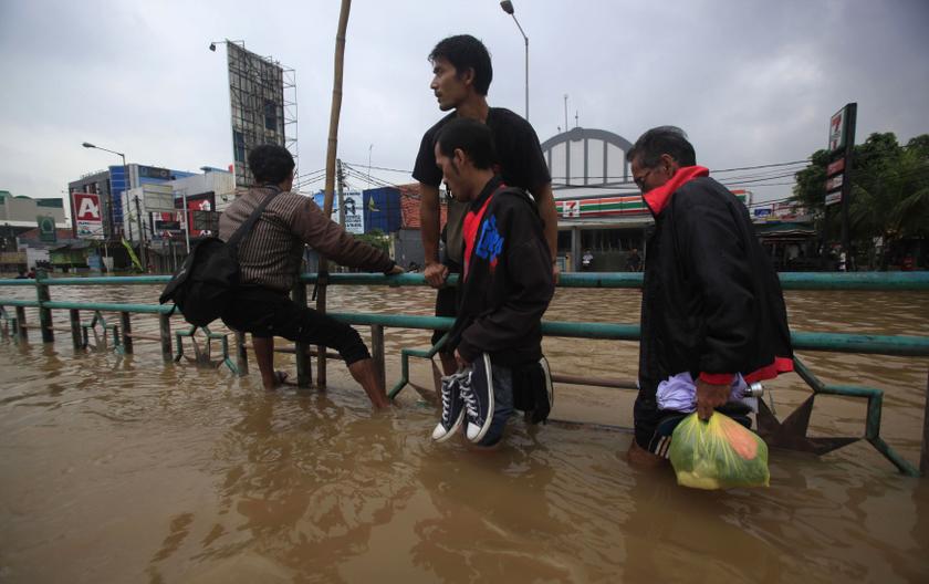 A resident clings to a road divider in an attempt to avoid the floodwaters in Jakarta January 13, 2014. u00e2u20acu201d Reuters pic