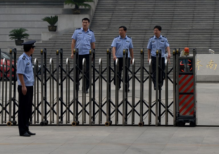Chinese police patrol outside the Intermediate People's Court, Jinan, Shandong Province on July 25, 2013. Eight police officers were sacked today after being caught skinny-dipping at a popular tourist spot u00e2u20acu201d AFP pic