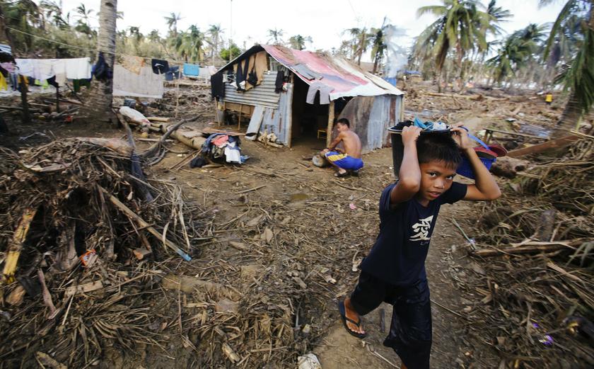 A survivor of Typhoon Haiyan carries a bucket of laundry from a nearby river in the eastern Samar costal village of Hernani November 18, 2013.  u00e2u20acu201d Reuters pic