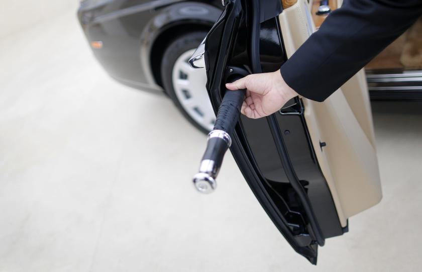 A Rolls-Royce salesman removes an umbrella from its storage place in the rear door of a Rolls-Royce Phantom in a showroom in Singapore October 8, 2013. — Reuters pic