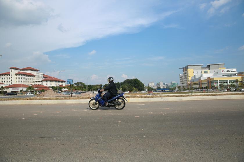 A motorcycle passes in front of Hospital Putrajaya and National Cancer Institute in Precinct 7. u00e2u20acu201d Picture by Saw Siow Feng