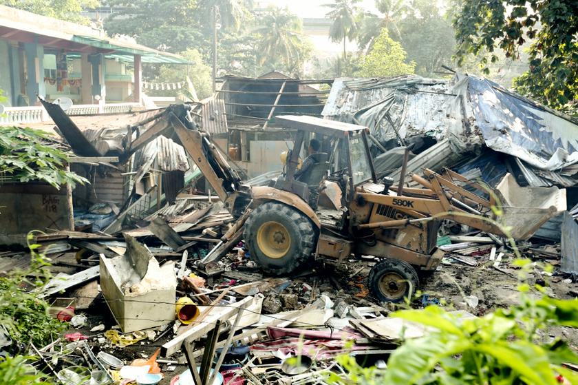 A bulldozer makes quick work of one of the vacant houses at Kg Railway in Sentul.