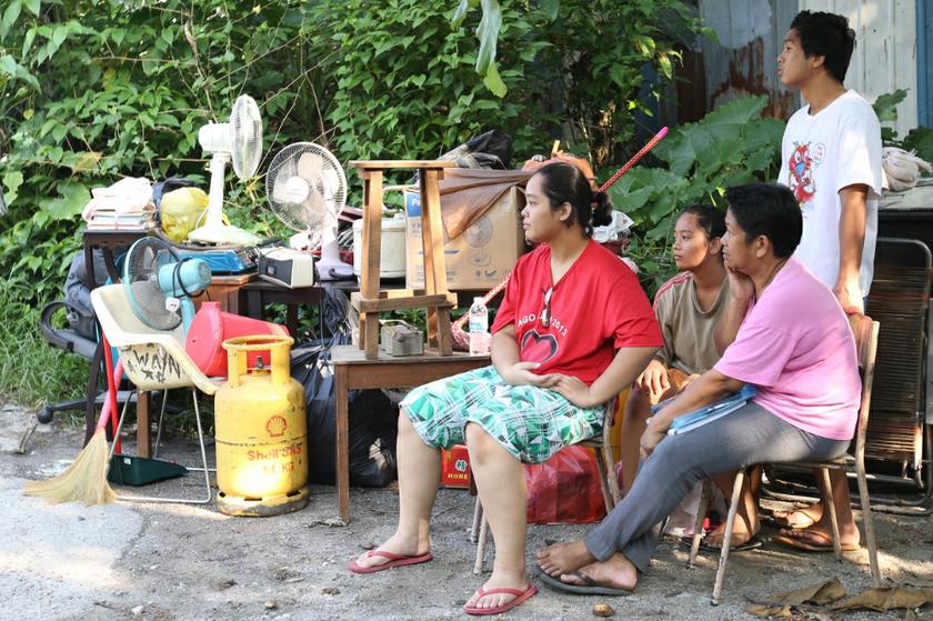 Residents of Kg Railway sit back as they watch their home get torn down while they wait for a lorry to pick up their belongings for their move to low-cost flats in Bukit Jalil.