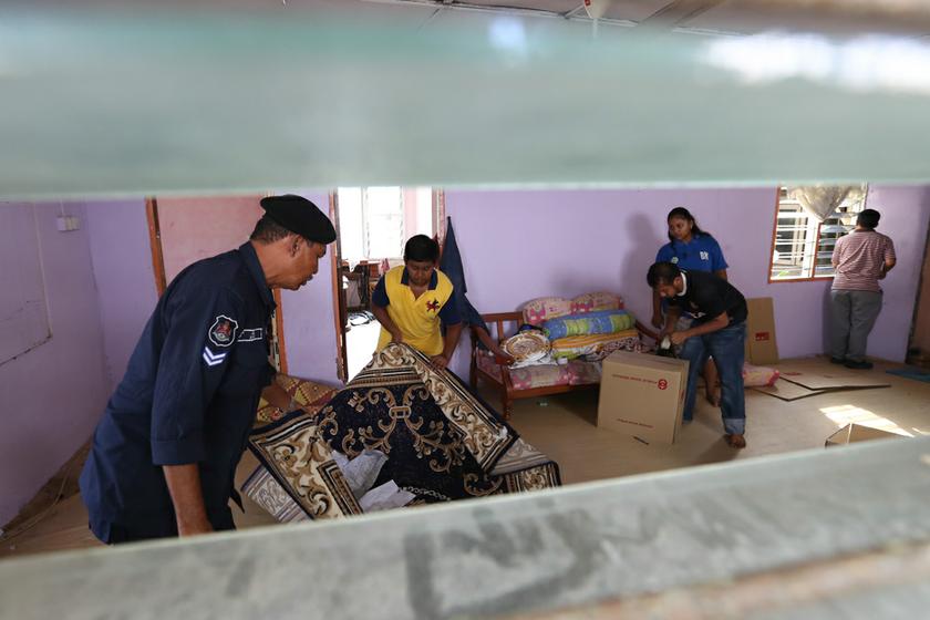 Kuala Lumpur City Hall enforcement officers help residents pack up before demolition workers tear down their house in Kg Railway.