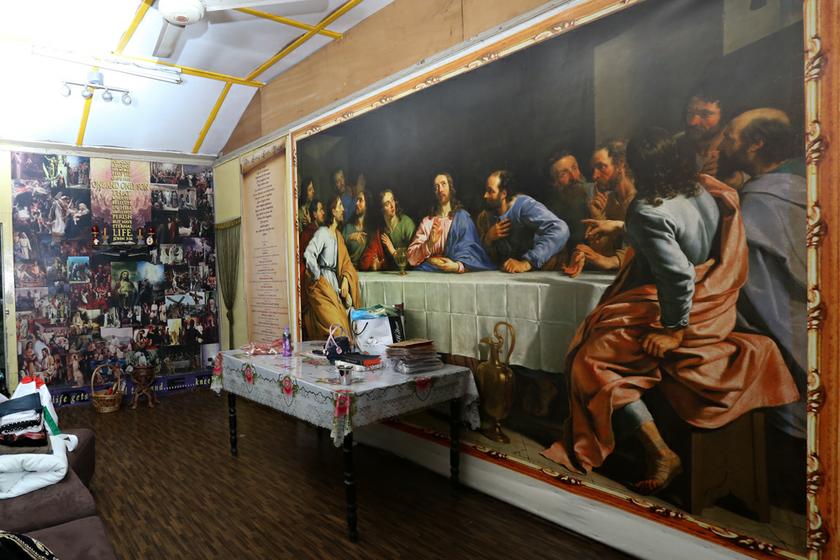 A wall-sized painting of the Last Supper adorns one wall of a house in Kg Railway. All the houses in the village were scheduled for demolition yesterday.