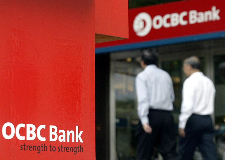 People walk past an Overseas Chinese Bank Corporation (OCBC) promotional display outside the companyu00e2u20acu2122s headquarters in Singapore, 14 November 2003. u00e2u20acu201d AFP pic