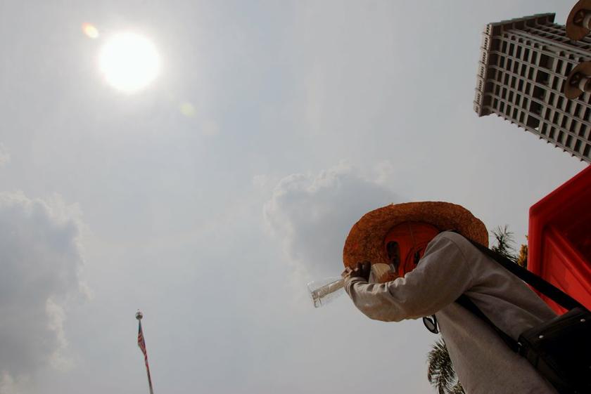 A worker drinks water to quench his thirst due to the soaring heat near Dataran Merdeka, February 17, 2014. u00e2u20acu201d Pictures by Yusof Mat Isa