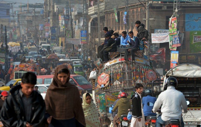 Pakistani students sit on the roof of a passenger bus on a street in Rawalpindi on January 18, 2014. Police in Karachi have launched a campaign to stop music being played in public transport. u00e2u20acu201d AFP pic