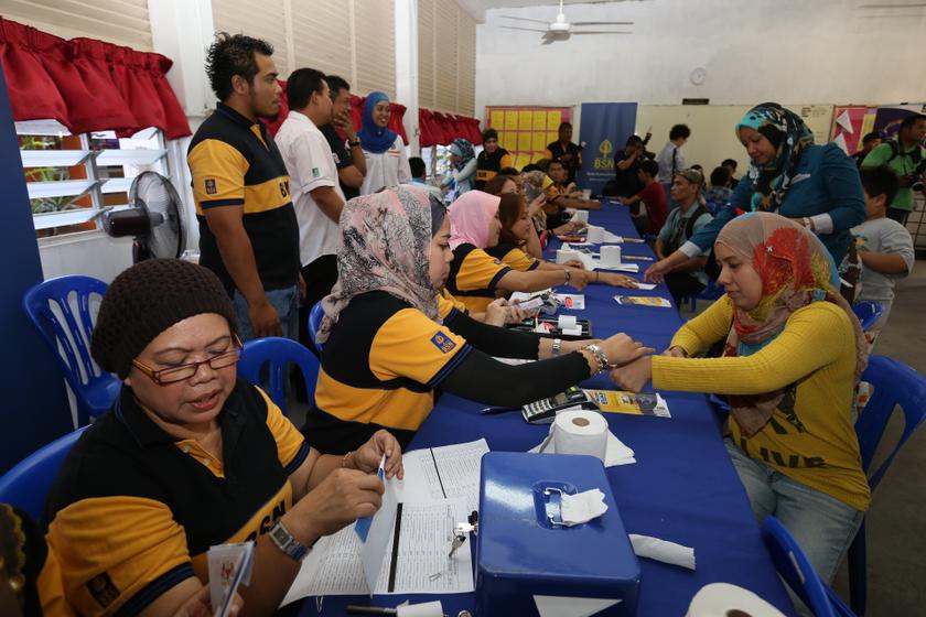 People exchange vouchers for cash at the launch of the national-level 1Malaysia People's Aid (BR1M) 2014 at SMK Aminuddin Baki, Kampung Pandan, Kuala Lumpur February 22, 2014. u00e2u20acu201d Picture by Saw Siow Feng