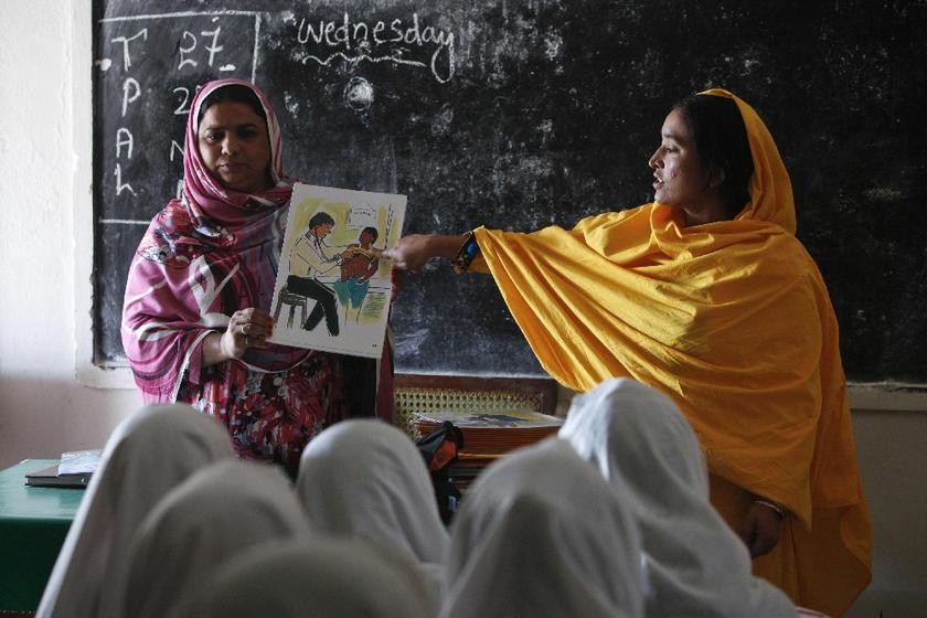 Teachers show a card with illustration depicting a girl going through a medical checkup by a doctor.