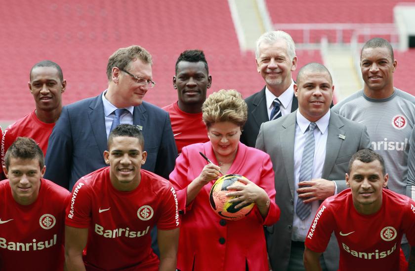 Brazilu00e2u20acu2122s President Dilma Rousseff (centre) signs a soccer ball as she poses for a picture with FIFA Secretary General Jerome Valcke (3rd left), former Brazilian soccer player and member of the 2014 World Cup local organizing committee Ronaldo (3rd right