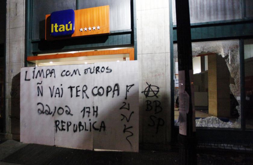 A sign left by protesters is pictured near the broken window of an Itau bank branch during a protest against Brazil's hosting of the 2014 World Cup, in Sao Paulo February 22, 2014. The sign reads, 'clean with interest, the bank. Will not have World Cup'.u00c2