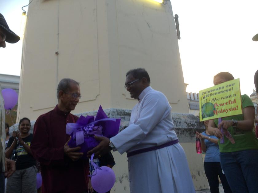 Ven Charles handing over a bouquet of flowers to Mohamed Yahaya at the Masjid Jamek.