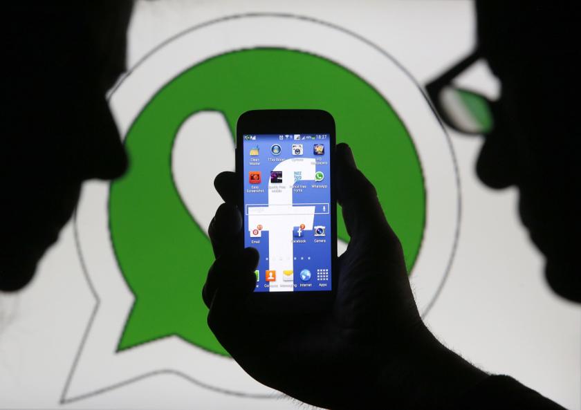 An illustration photo shows a man holding a smart phone with a Facebook logo as its screen wallpaper in front of a WhatsApp messenger logo, in Zenica February 20, 2014. u00e2u20acu2022 Reuters pic