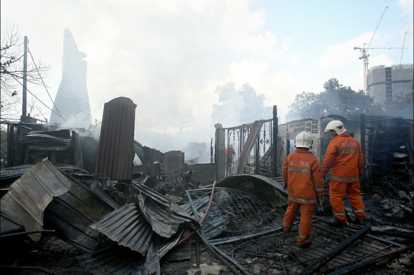 Firemen inspecting the site of a blaze at Kampung Kerinchi on February 13, 2014.
