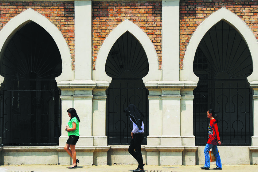 A man pulls his jacket over his head to hide from the heat in Kuala Lumpur. u00e2u20acu201d Picture by Arif Kartono