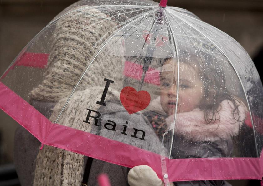 A girl shelters under an umbrella during during a rainstorm in London February 14, 2014.  u00e2u20acu201d Reuters pic