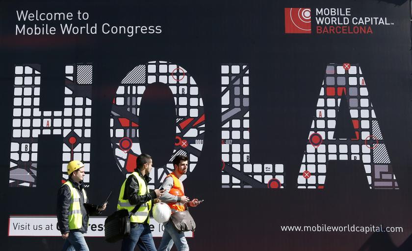 Workers walk past a Mobile World Congress banner in Barcelona, February 22, 2014. u00e2u20acu2022 Reuters picn