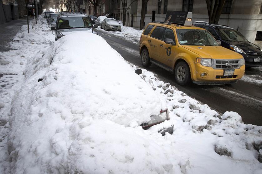 A taxi passes a car that is completely inundated by snow and ice that have accumulated from recent storms in the Manhattan borough of New York February 16, 2014. u00e2u20acu201d Reuters pic