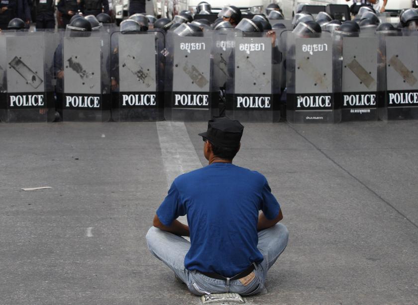 An anti-government protester sits on a main road as riot police stand guard at a barricade near the Government Complex in Bangkok February 14, 2014. u00e2u20acu201d Reuters pic