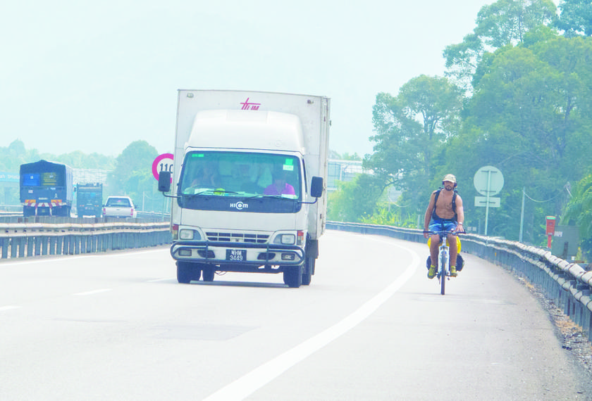 Argentinian tourist Nicolas Tonnelier, sans shirt because of the heat, cycles from Ipoh to Taiping along the North South Expressway u00e2u20acu201d Picture by Fernando Fong.