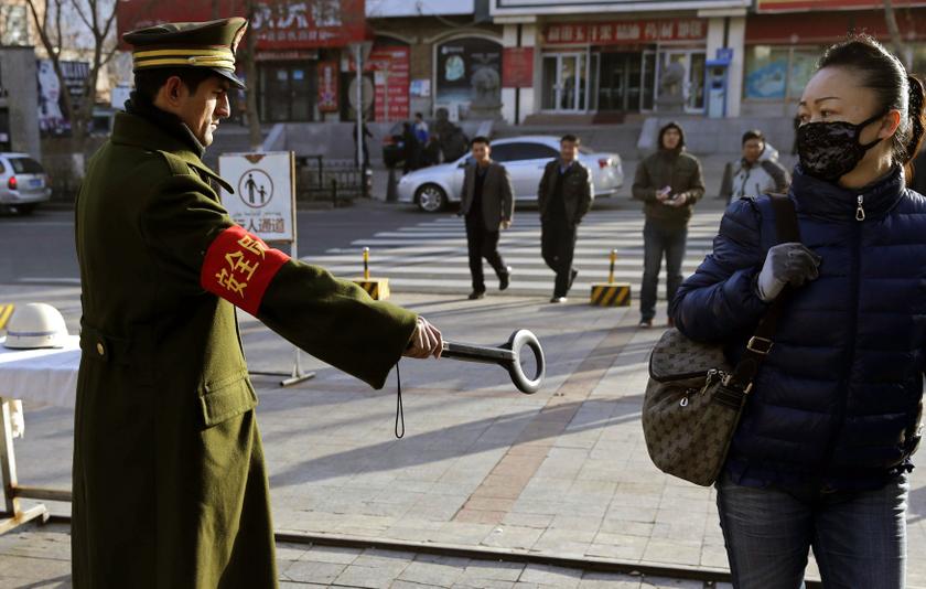 A pedestrian reacts as a security officer holds out a detector on a street in Urumqi, Xinjiang Uighur autonomous region, November 17, 2013. u00e2u20acu2022 Reuters pic