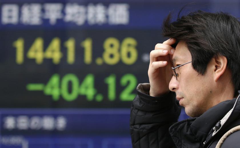 A man walks past an electronic board displaying Japan's Nikkei average outside a brokerage in Tokyo March 14, 2014.  u00e2u20acu201d Reuters pic