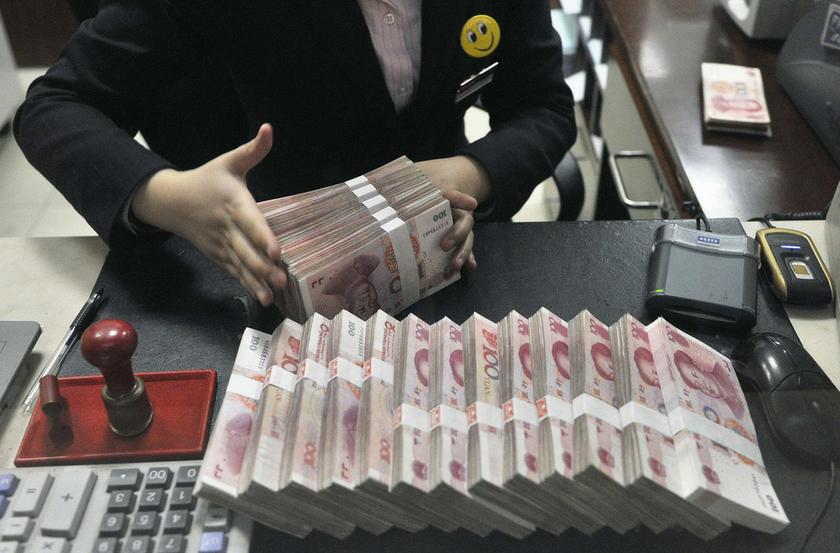 A clerk arranges bundles of 100 Chinese yuan banknotes at a branch of China Merchants Bank in Hefei, Anhui province March 17, 2014. u00e2u20acu201d Reuters pic