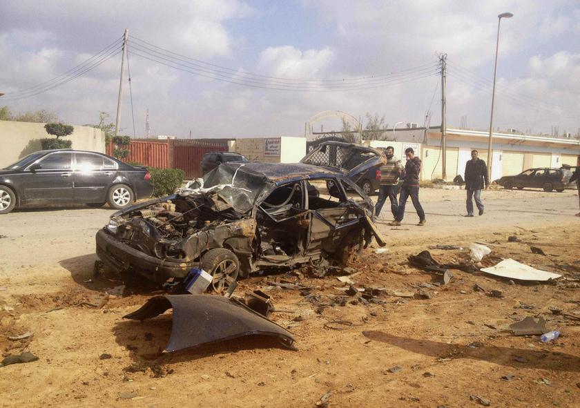 Men walk next to a wreckage of a car after an explosion in the eastern city of Benghazi March 17, 2014. u00e2u20acu201d Reuters pic