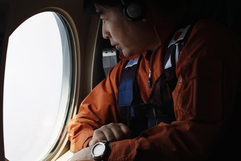 A Japan Coast Guard officer looks out the window of a Gulfstream V Jet aircraft, customized for search and rescue operations, as they search for the missing Malaysia Airlines MH370 plane over the waters of the South China Sea March 15, 2014. u00e2u20acu201d Reuters p