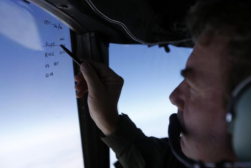 Squadron leader Brett McKenzie marks the name of another search aircraft on the windshield of a Royal New Zealand Air Force P-3K2 Orion aircraft searching for missing Malaysian Airlines flight MH370 over the southern Indian Ocean March 22, 2014. u00e2u20acu201d Reute