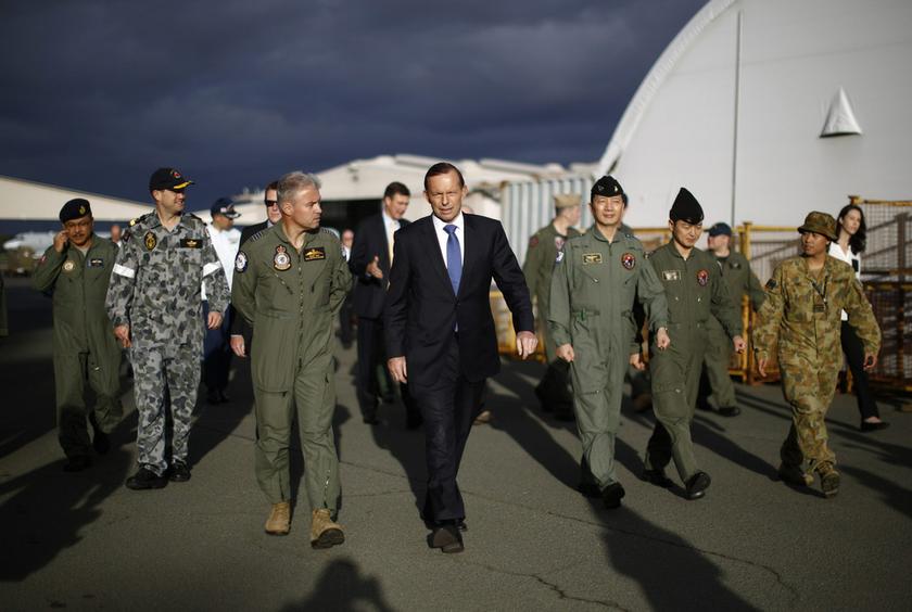 Australia's Prime Minister Tony Abbott walks with Australia's Air Force Group Commander Craig Heap (third left) and leaders of international military forces currently based in Perth during Abbott's visit to RAAF Base Pearce near Perth March 31, 2014. — Reuters pic