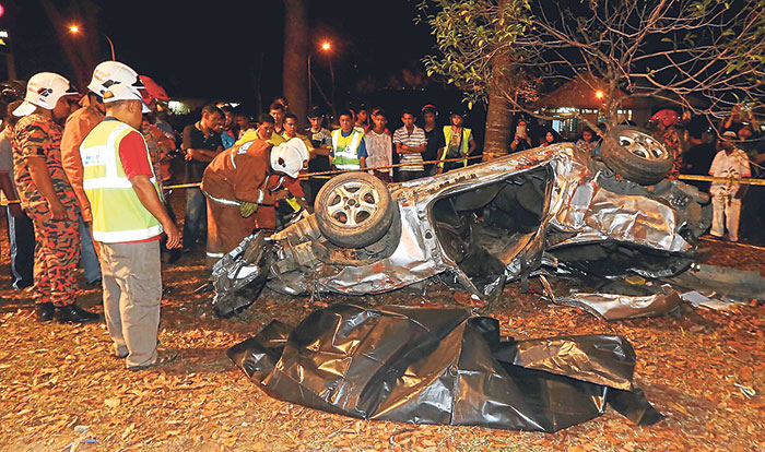 A fire officer checks the wreckage of the car u00e2u20acu201d Picture by Sayuti Zainudin