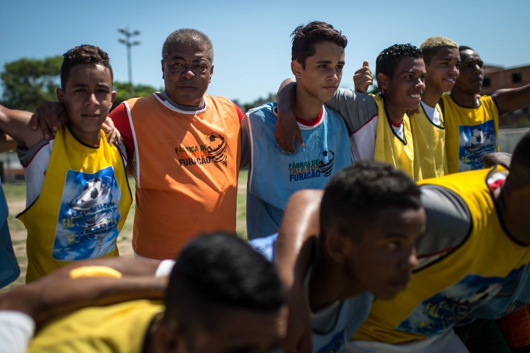 Former Brazilian football player Jair Ventura Filho aka Jairzinho (second left) embraces the youngsters he coaches during a project to find a talent at Varginha shantytown in Rio de Janeiro, Brazil, on March 20, 2014. u00e2u20acu201d Reuters pic