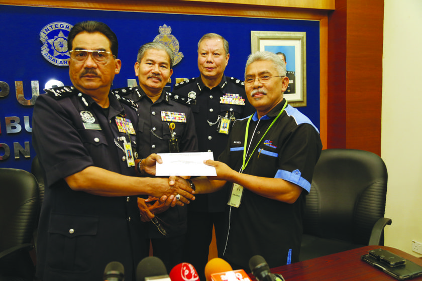 Jalaluddin (left) hands over the reports to Suhaidi. 