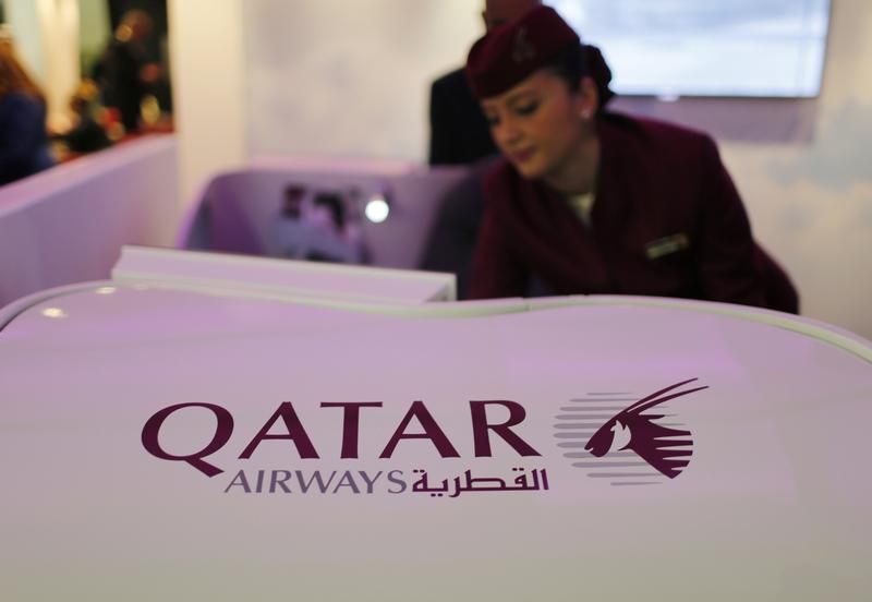 A Qatar Airways flight stewardess shows the airline's new business class seat during the Arabian Travel Market exhibition in Dubai May 6, 2013 Reuters