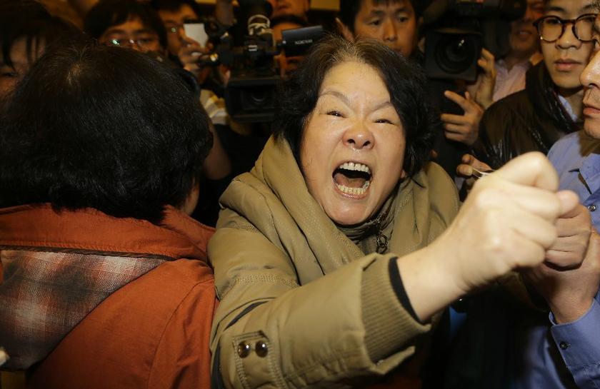 A family member of a passenger aboard Malaysia Airlines MH370 shouts at journalists after watching a television broadcast of a news conference, at the Lido hotel in Beijing, March 24, 2014 Reuters