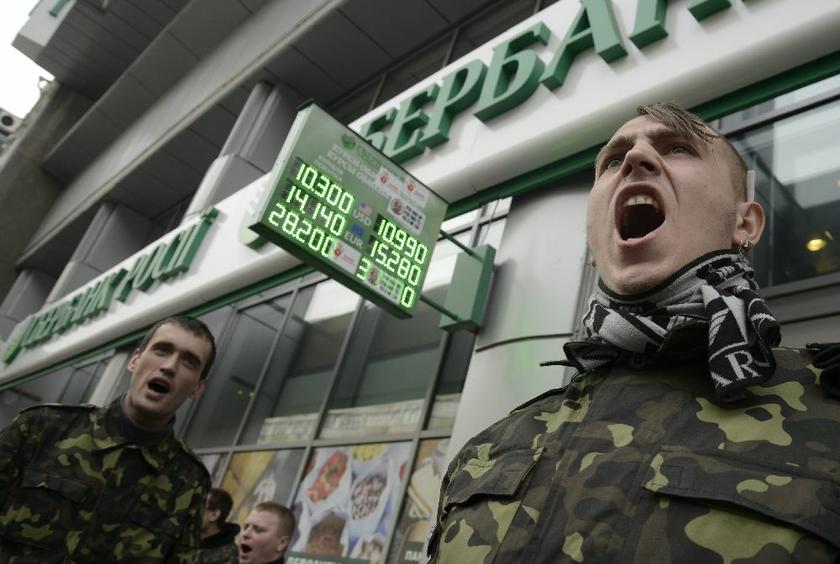 The pall of Ukraine hangs over the markets. Here, members of Ukrainian self-defence units hold a rally outside an office of Sberbank of Russia, in Kiev, March 26, 2014, because of its Russian origin Reuters