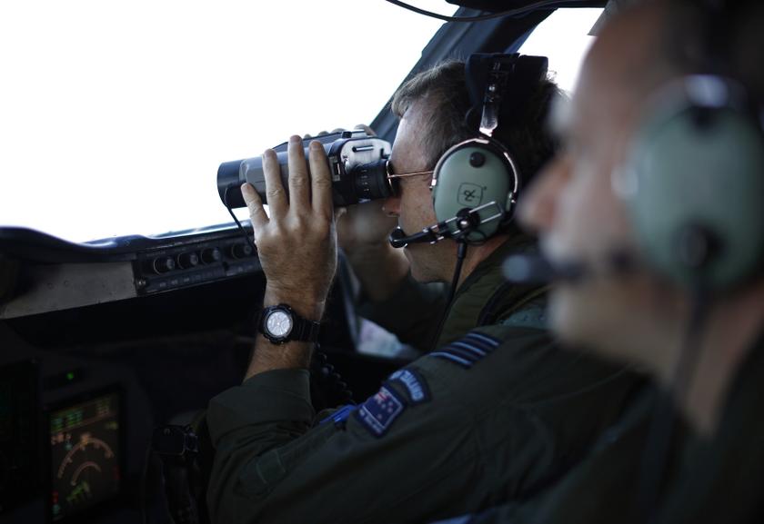 Wing Commander Rob Shearer looks through binoculars on the flight deck of a Royal New Zealand Air Force P-3K2 Orion aircraft during a search for the missing Malaysian Airlines flight MH370 over the southern Indian Ocean, March 29, 2014. u00e2u20acu201d Reuters pic