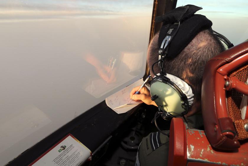 Flight Lieutenant Jason Nichols aboard a Royal Australian Air Force (RAAF) AP-3C Orion, writes notes as they search for missing Malaysian Airlines flight MH370 over the southern Indian Ocean March 22, 2014. u00e2u20acu201d Reuters pic