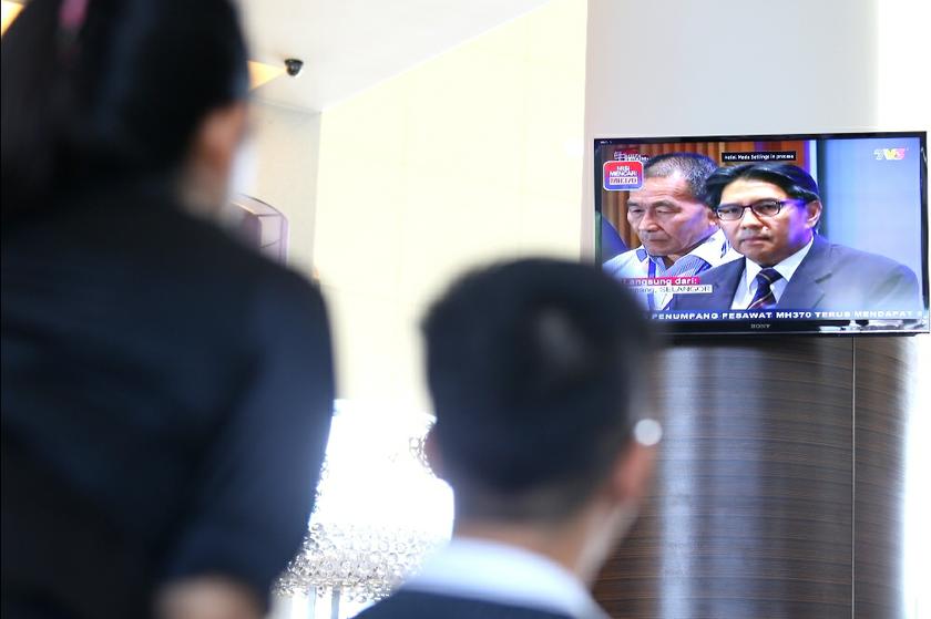 A relative of a passenger on the missing MH370 flight watches DCA director-general Datuk Azharuddin Abdul Rahman during a televised news conference at the Everly Hotel in Putrajaya March 10, 2014. u00e2u20acu201d Picture by Saw Siow Feng