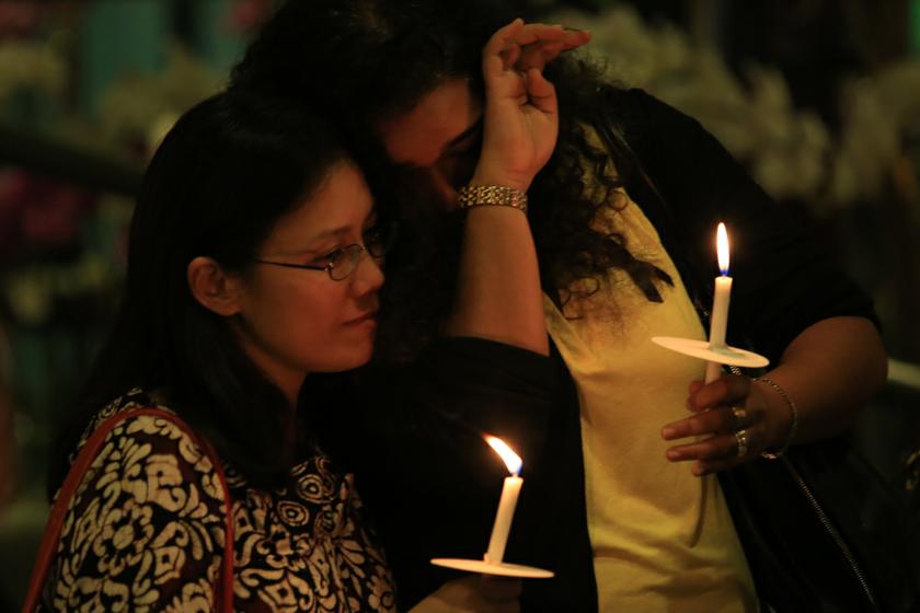 Women hold candles at a candlelight vigil for passengers on board the missing MAS flight MH370 at the Bangsar Village shopping mall, on March 27, 2014. u00e2u20acu201d Picture by Saw Siow Feng