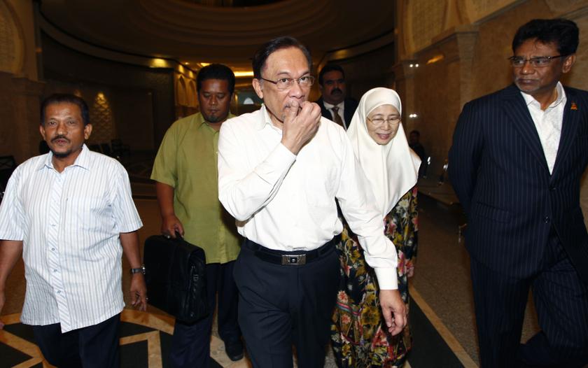 Malaysian opposition leader Datuk Seri Anwar Ibrahim (centre) and his wife Datuk Seri Dr Wan Azizah arrive at a court house in Putrajaya March 7, 2014. u00e2u20acu201d Reuters pic