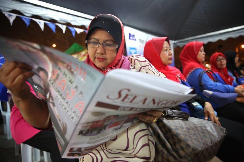 People reading the u00e2u20acu02dcSelangor Hari Iniu00e2u20acu2122 newspaper given out at the BN ceramah at Taman Saujana Impian, Kajang March 2, 2014. u00e2u20acu2022 Picture by Choo Choy May
